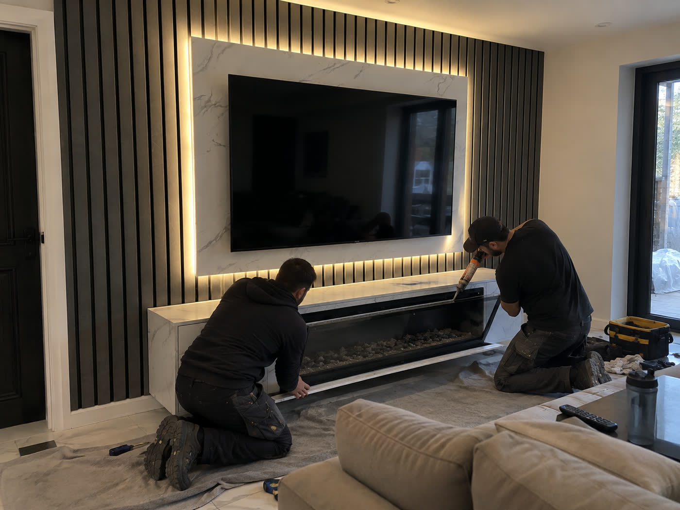 Fitters sealing a linear fireplace into a porcelain media unit
